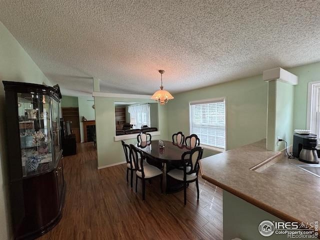 dining space with a textured ceiling and dark wood-type flooring