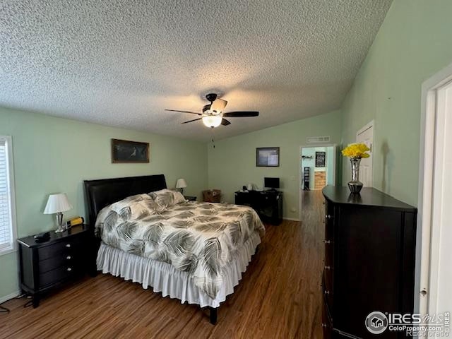 bedroom with dark wood-style floors, a textured ceiling, lofted ceiling, and ceiling fan