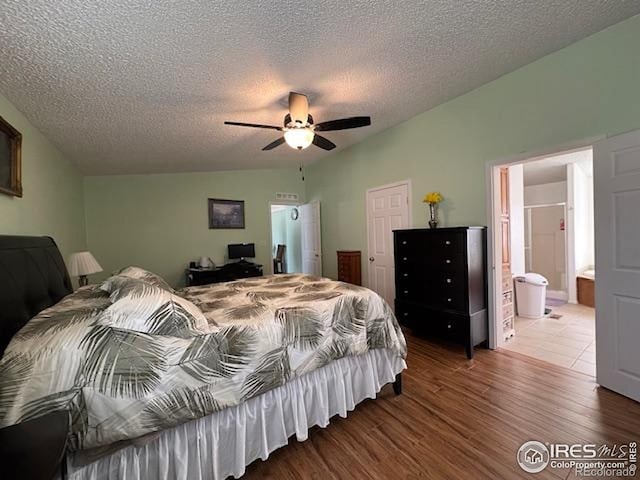 bedroom featuring wood finished floors, a textured ceiling, ensuite bathroom, ceiling fan, and a closet
