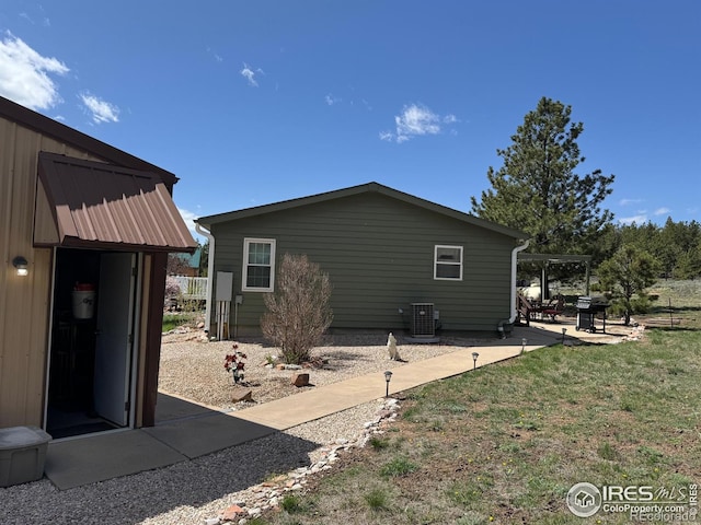 view of side of home featuring a patio and central air condition unit