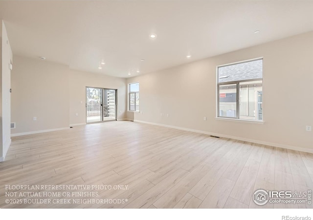 spare room featuring light wood-style floors, baseboards, and recessed lighting