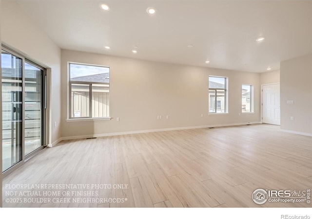 unfurnished room with light wood-type flooring, recessed lighting, and baseboards