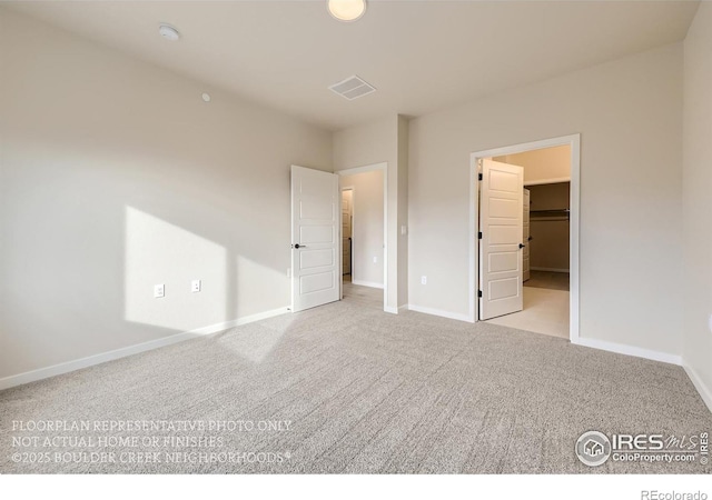 unfurnished bedroom with carpet floors, baseboards, and a spacious closet