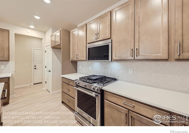 kitchen featuring stainless steel appliances, recessed lighting, tasteful backsplash, light countertops, and baseboards