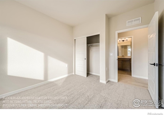 unfurnished bedroom featuring carpet flooring, baseboards, a closet, and a sink