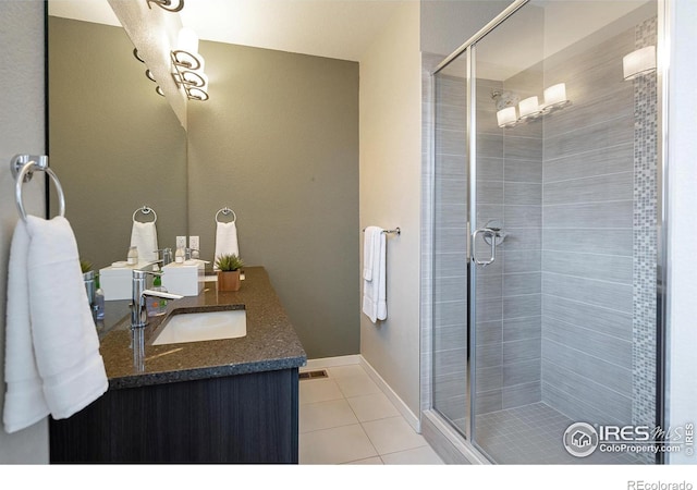 2100 N Clay St, Denver, CO 80211 - bathroom with tile patterned floors, a stall shower, vanity, and baseboards