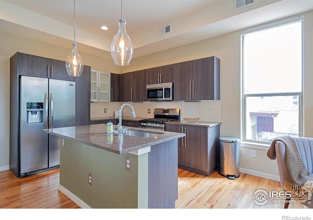2100 N Clay St, Denver, CO 80211 - kitchen featuring appliances with stainless steel finishes, a sink, light wood finished floors, dark stone countertops, and recessed lighting