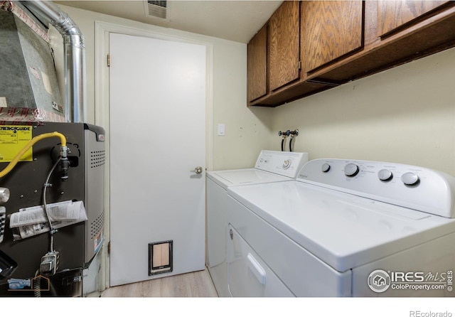 4140 Monroe Dr Unit C, Boulder, CO 80303 - clothes washing area with washer and clothes dryer, cabinet space, light wood-style flooring, and heating unit