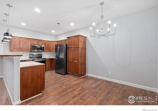 kitchen featuring stainless steel appliances, dark wood-type flooring, a chandelier, light countertops, and baseboards