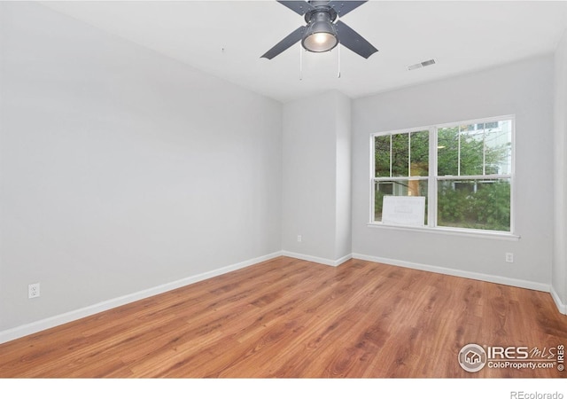 spare room with wood finished floors, baseboards, and ceiling fan