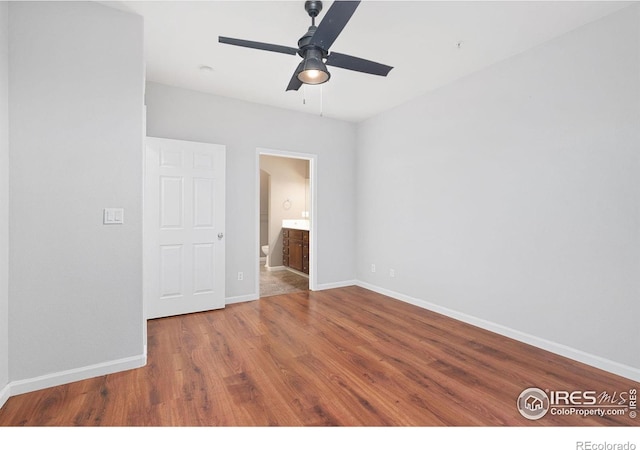 empty room with wood finished floors, baseboards, and ceiling fan