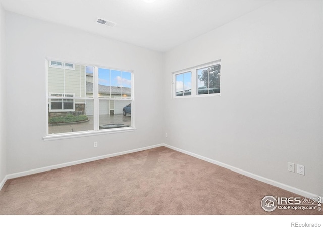 carpeted spare room with baseboards