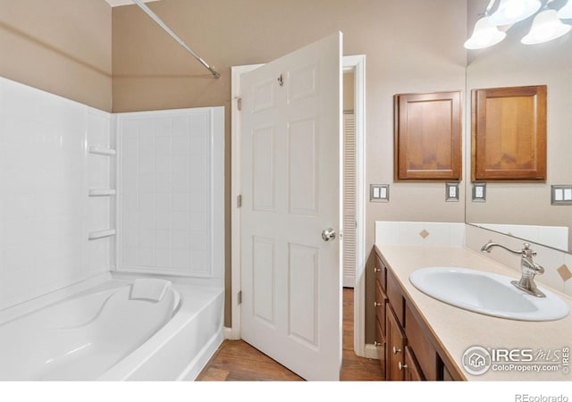 bathroom featuring wood finished floors, vanity, and bathtub / shower combination