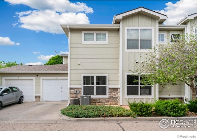 3639 29th St Unit 7, Greeley, CO 80634 - view of front of home featuring board and batten siding, an attached garage, driveway, and stone siding