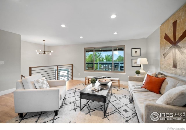 living room featuring a chandelier, wood finished floors, baseboards, and recessed lighting