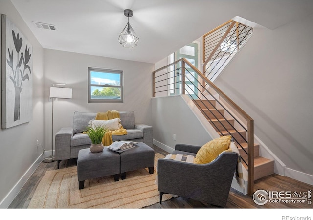 living area featuring wood finished floors, baseboards, and stairs