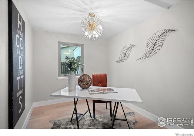 office space with a chandelier, baseboards, and light wood-type flooring