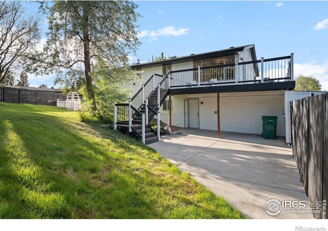 back of property featuring driveway, a garage, stairs, and a wooden deck