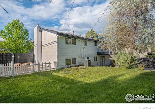 rear view of house featuring a chimney, central AC unit, an attached garage, and a wooden deck