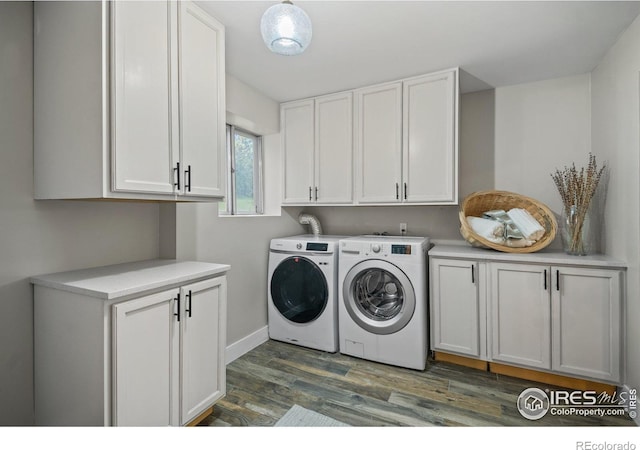 laundry area with cabinet space, washer and dryer, dark wood finished floors, and baseboards
