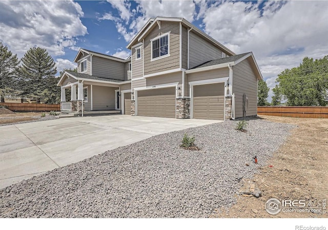 2710 Crystal Spgs, Longmont, CO 80503 - view of side of home with an attached garage, driveway, a porch, and stone siding