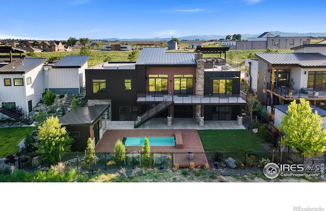 2123 Picture Point Dr, Windsor, CO 80550 - rear view of house featuring a fenced backyard, a residential view, stairs, a standing seam roof, and a patio area