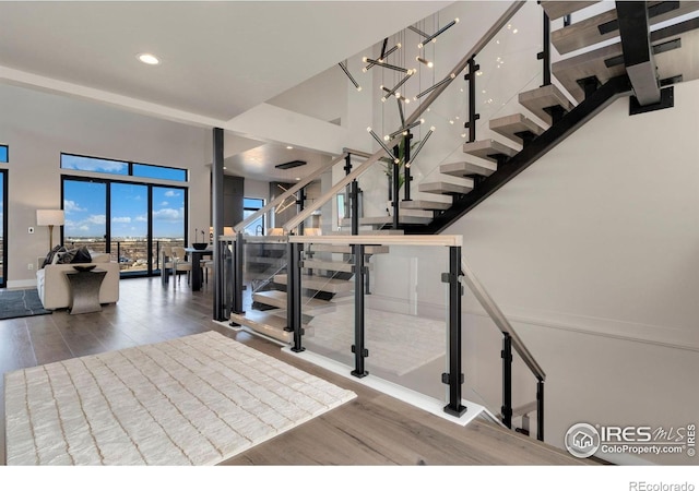 2123 Picture Point Dr, Windsor, CO 80550 - stairway featuring wood finished floors, baseboards, recessed lighting, and a towering ceiling