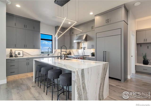 2123 Picture Point Dr, Windsor, CO 80550 - kitchen featuring gray cabinets, paneled refrigerator, exhaust hood, a sink, and recessed lighting