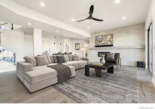 2123 Picture Point Dr, Windsor, CO 80550 - living room featuring wood finished floors, recessed lighting, a ceiling fan, and a glass covered fireplace