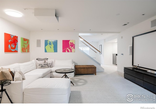 carpeted living area with stairs