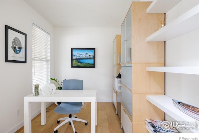 office space with light wood-style flooring and baseboards