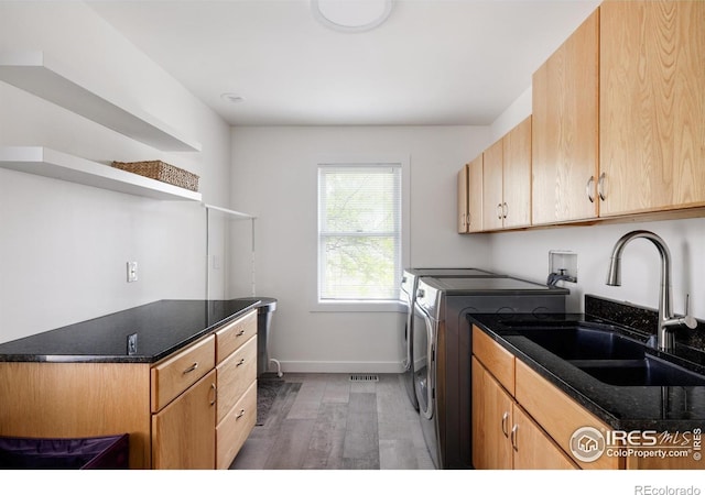 laundry area with washing machine and clothes dryer, wood finished floors, baseboards, and cabinet space