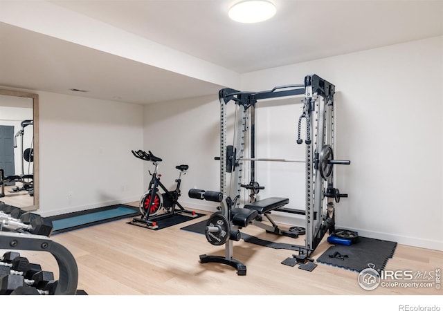 workout room with wood finished floors and baseboards