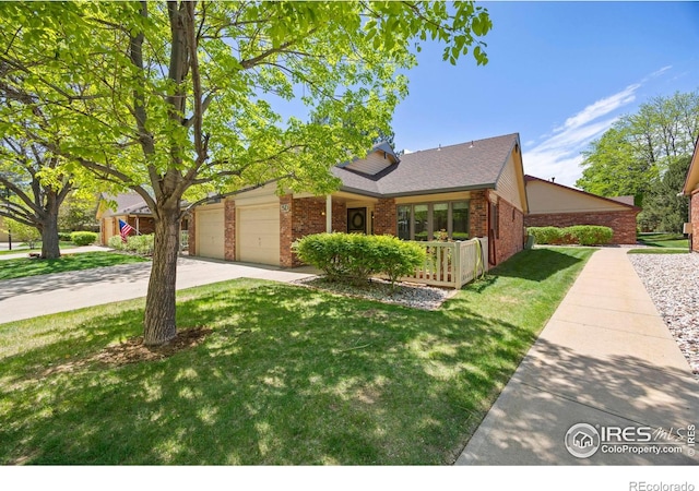 4560 Larkbunting Dr Unit 5D, Fort Collins, CO 80526 - view of front of house featuring brick siding, a front yard, concrete driveway, and a garage