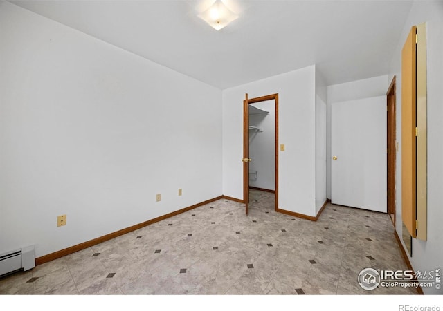 4560 Larkbunting Dr Unit 5D, Fort Collins, CO 80526 - unfurnished bedroom featuring a baseboard heating unit, baseboards, tile patterned floors, and a walk in closet