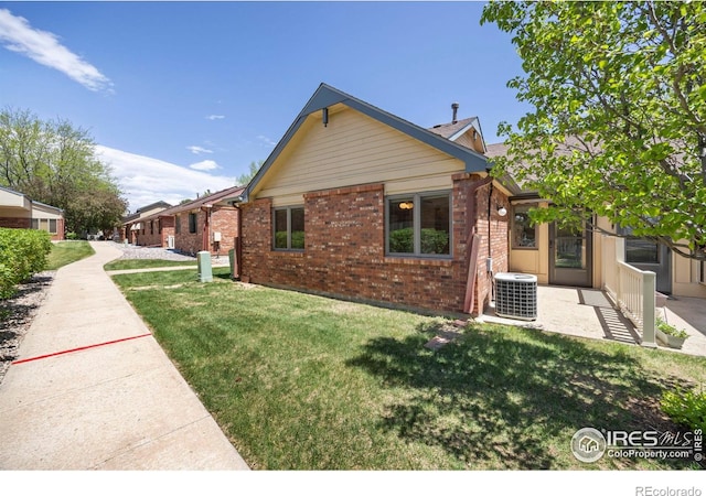 4560 Larkbunting Dr Unit 5D, Fort Collins, CO 80526 - view of property exterior featuring central air condition unit, brick siding, and a yard