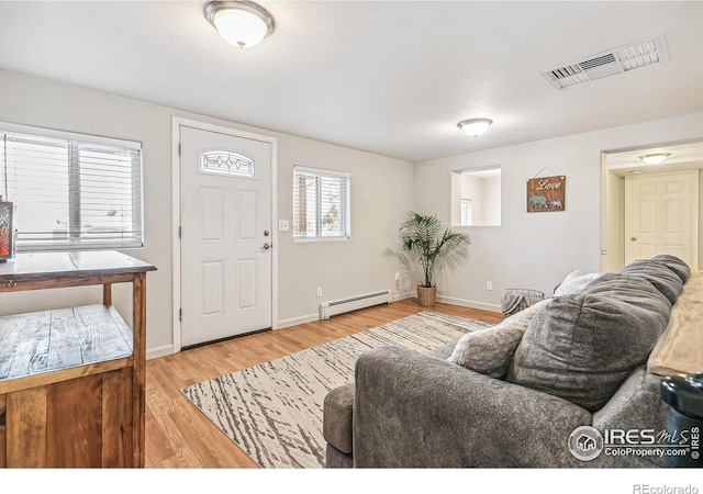 1970 Willow St, Denver, CO 80220 - living room featuring a baseboard heating unit, wood finished floors, and baseboards