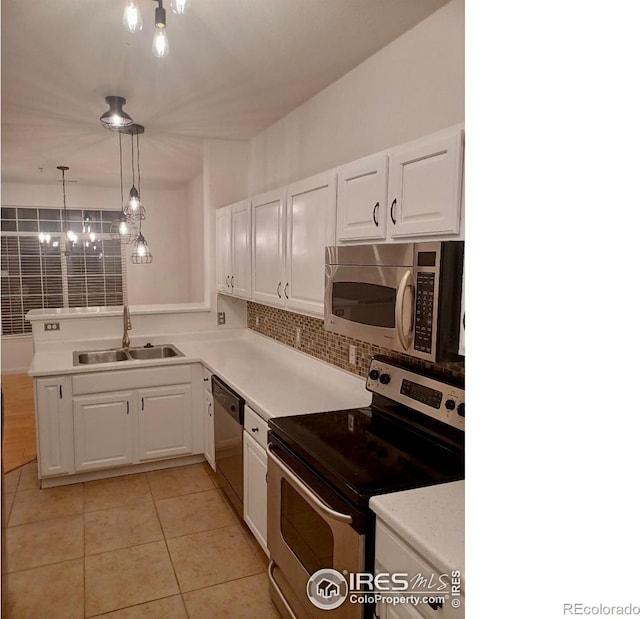 kitchen with stainless steel appliances, a sink, white cabinetry, light countertops, and light tile patterned floors
