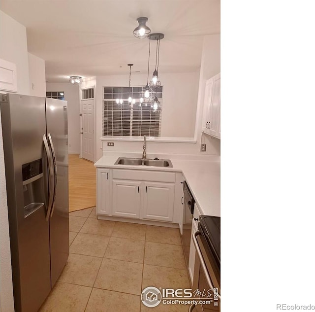 kitchen featuring stainless steel refrigerator with ice dispenser, a sink, range with electric stovetop, white cabinetry, and light tile patterned flooring