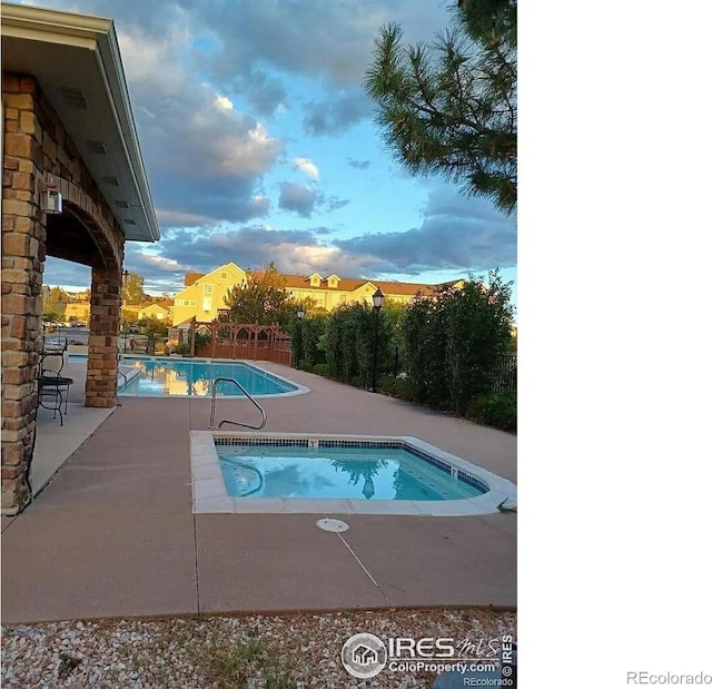 community pool featuring a community hot tub and a patio