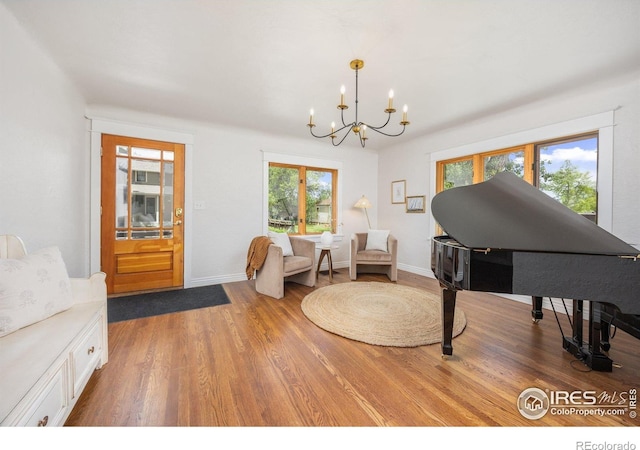 living area with a chandelier, wood finished floors, and baseboards
