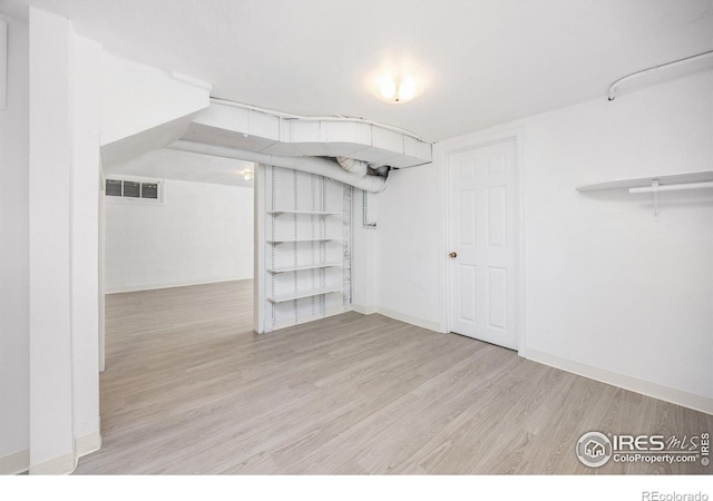 finished below grade area featuring wood finished floors and baseboards
