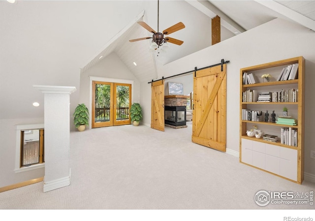 unfurnished living room featuring a ceiling fan, a barn door, carpet, recessed lighting, and baseboards