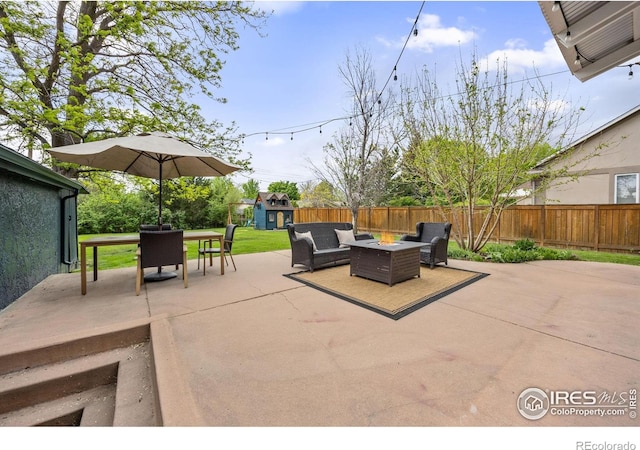 view of patio with a shed, an outbuilding, an outdoor living space with a fire pit, and outdoor dining area