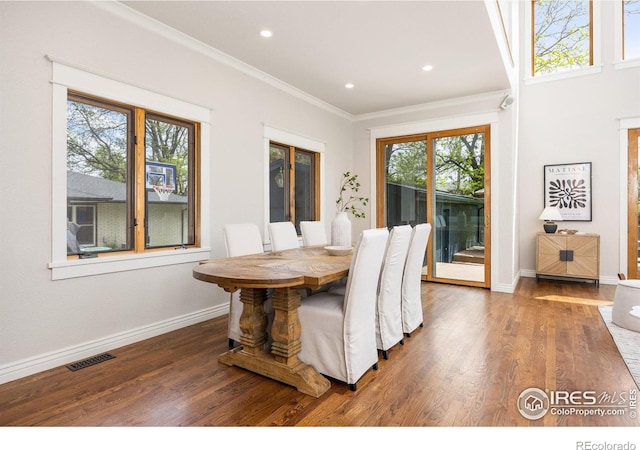 dining room featuring ornamental molding, wood finished floors, baseboards, and recessed lighting