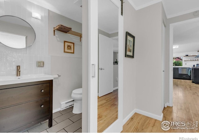 3582 Smuggler Way, Boulder, CO 80305 - bathroom with a baseboard heating unit, backsplash, vanity, wood finished floors, and toilet