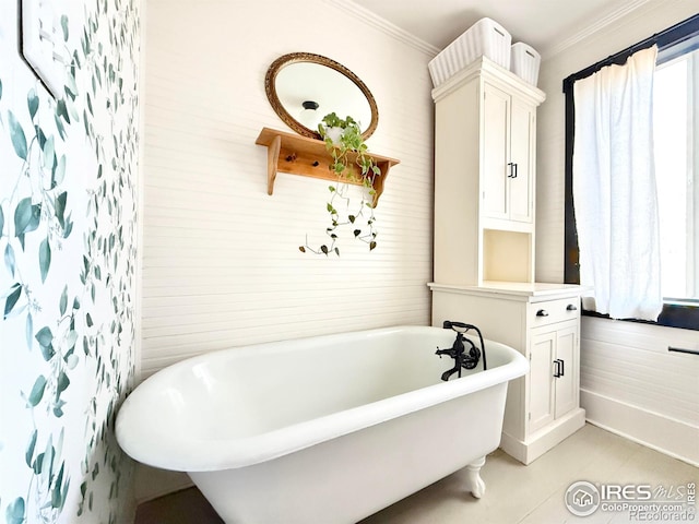 bathroom featuring crown molding, a freestanding tub, and tile patterned flooring