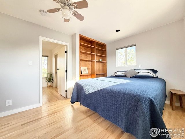 bedroom featuring light wood-style floors, baseboards, and a ceiling fan