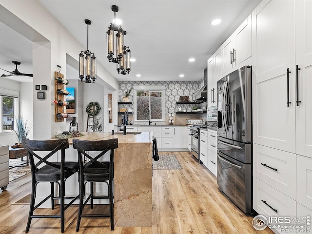 370 Big Boulder Dr, Estes Park, CO 80517 - kitchen with stainless steel appliances, open shelves, light stone counters, recessed lighting, and light wood finished floors
