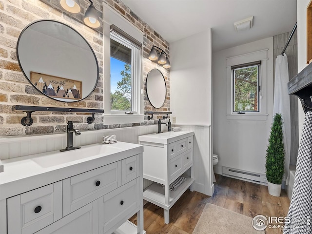 370 Big Boulder Dr, Estes Park, CO 80517 - bathroom with baseboard heating, toilet, wainscoting, plenty of natural light, and two vanities